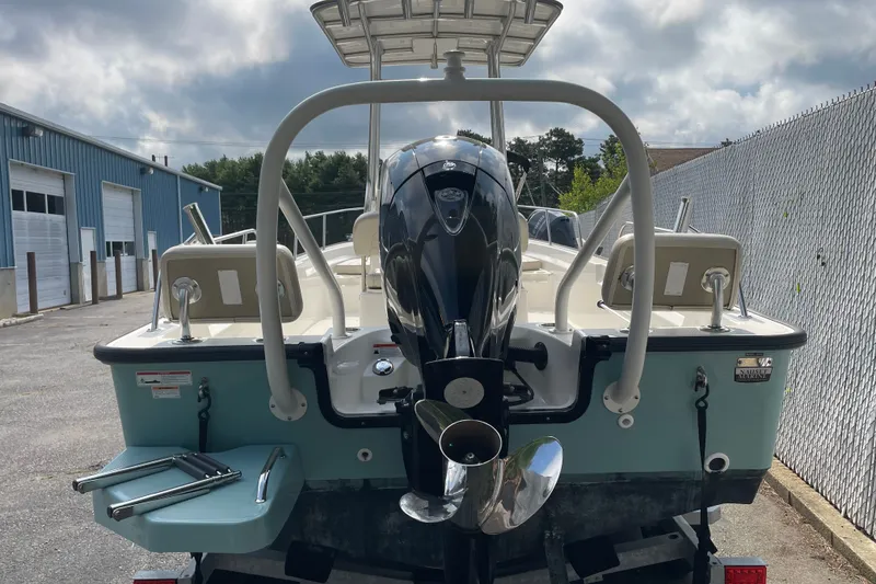 Slide: The Image of 2023 Boston Whaler 190 Montauk boat, rear view with outboard motor, parked outdoors. - 9