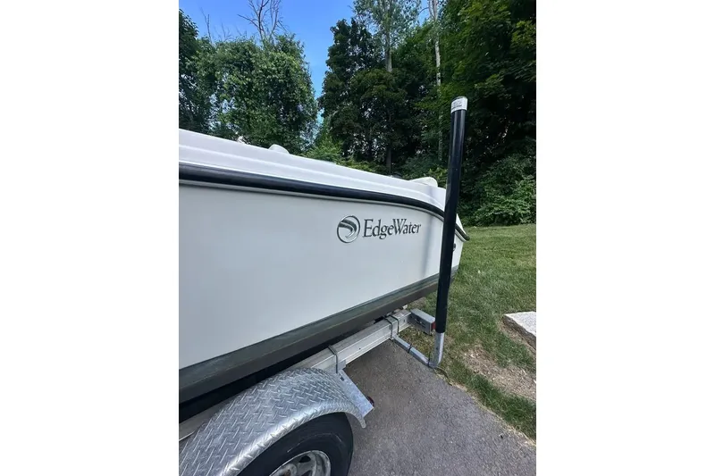 Slide: The Image of 2021 Edgewater 170CC boat on trailer, parked near lush greenery. - 1