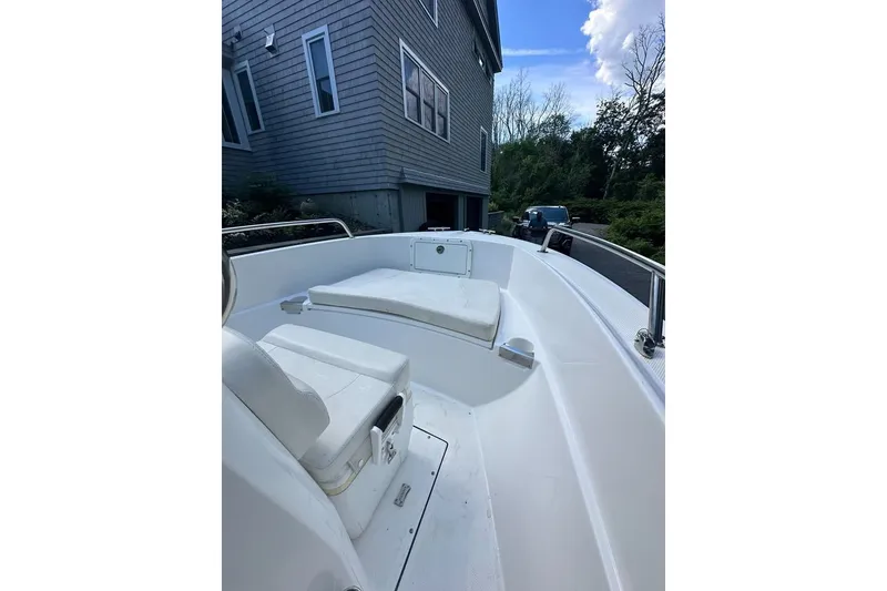 Slide: The Image of 2021 Edgewater 170CC boat parked beside a house, showcasing its seating area. - 12