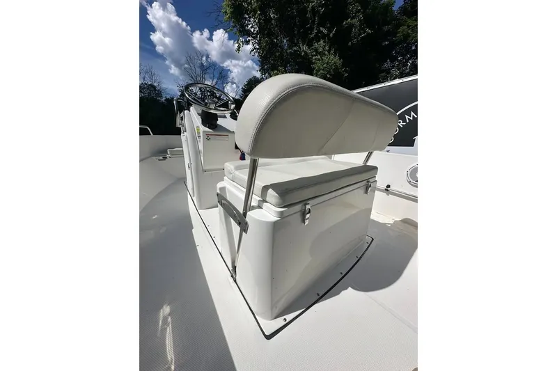 Slide: The Image of 2021 Edgewater 170CC boat interior with cushioned seating and steering console. - 9