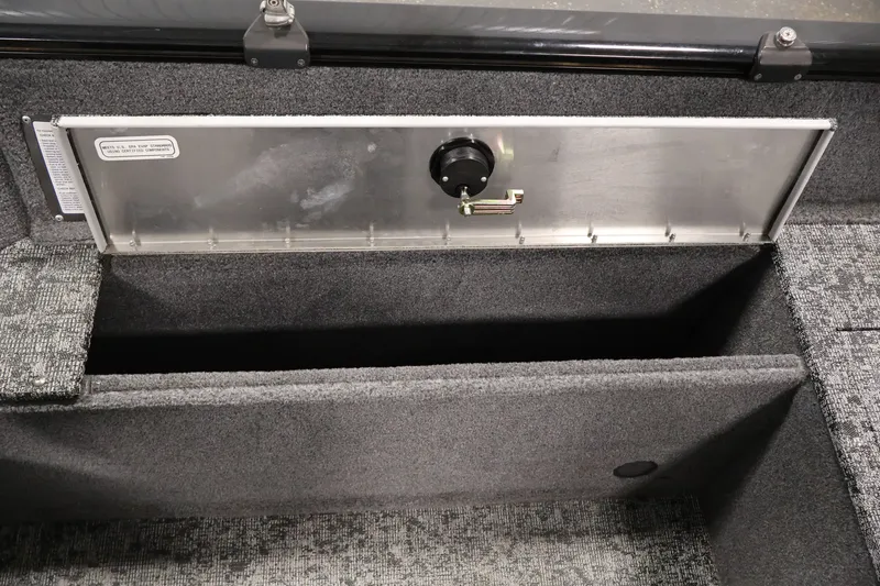 Slide: The Image of 2025 Tracker Pro Guide V-175 WT boat storage compartment with secure latch and carpeted interior. - 39