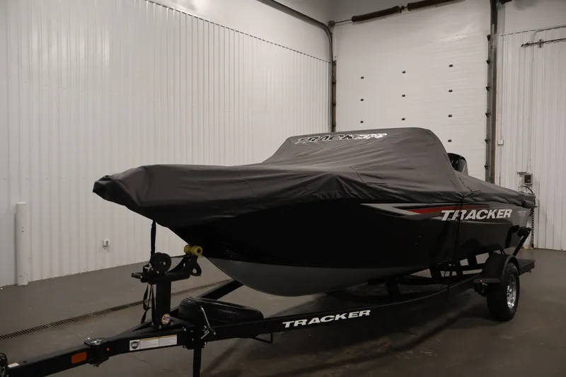 Slide: The Image of 2025 Tracker Pro Guide V-175 WT boat covered in a garage setting. - 53