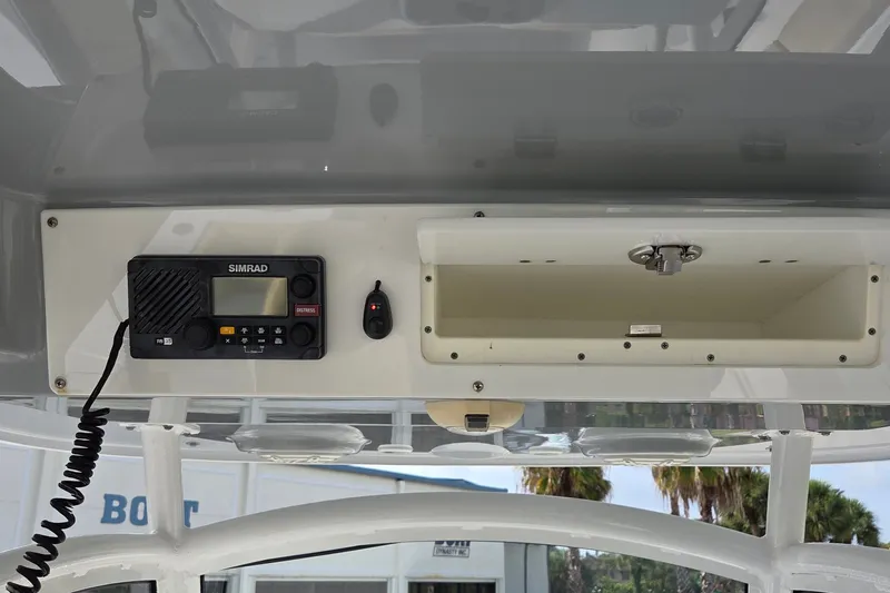 Slide: The Image of 2018 Sportsman Open 312 Center Console dashboard with Simrad radio and storage compartment. - 17