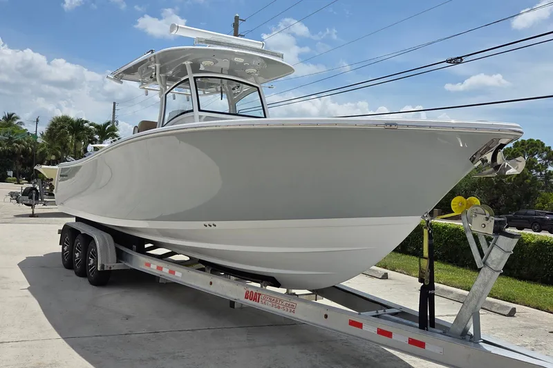 Slide: The Image of 2018 Sportsman Open 312 Center Console boat on trailer, parked outdoors. - 2