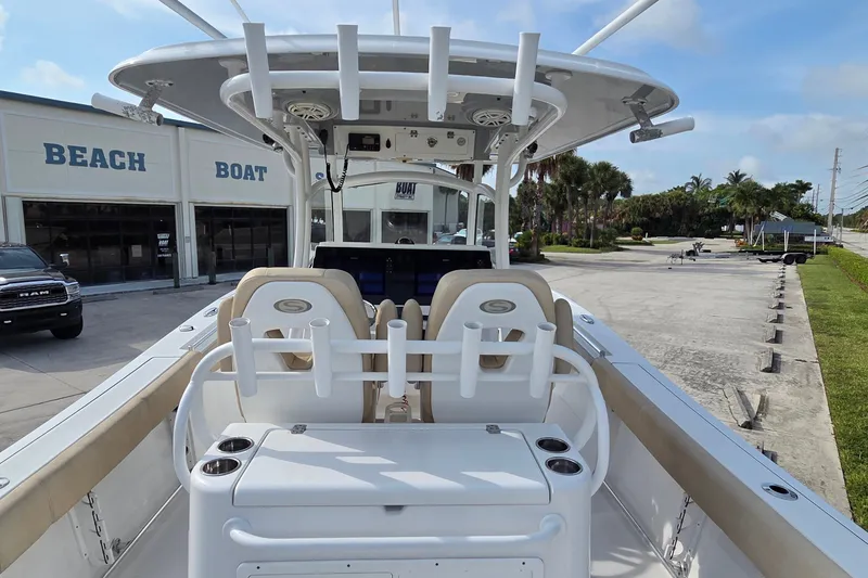 Slide: The Image of 2018 Sportsman Open 312 Center Console boat at a marina with palm trees. - 13
