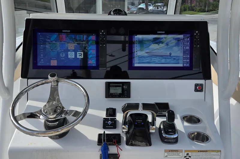Slide: The Image of 2018 Sportsman Open 312 Center Console dashboard with dual Simrad displays and steering wheel. - 19