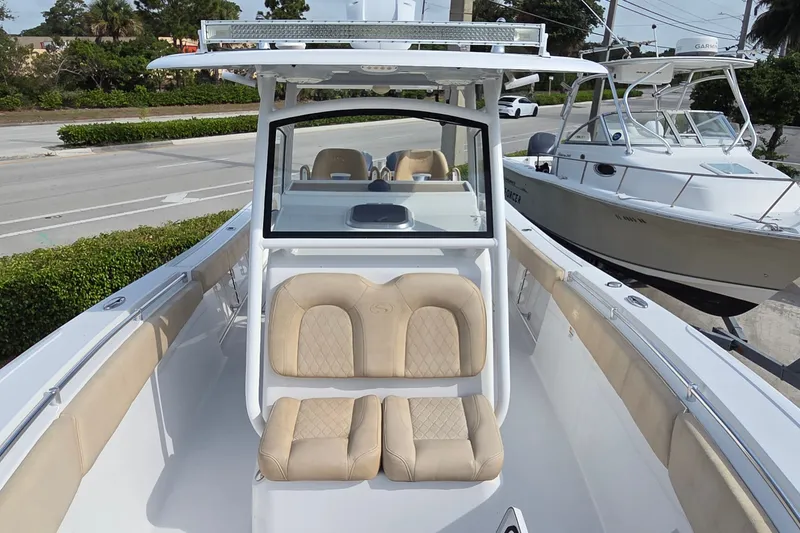 Slide: The Image of 2018 Sportsman Open 312 Center Console boat with beige seating, docked near other boats. - 8