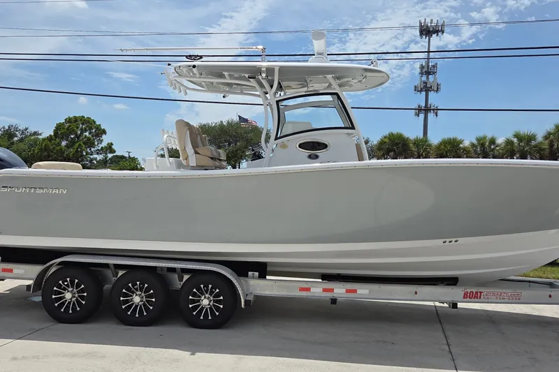 The Image of 2018 Sportsman Open 312 Center Console boat on a trailer, parked outdoors. - 1
