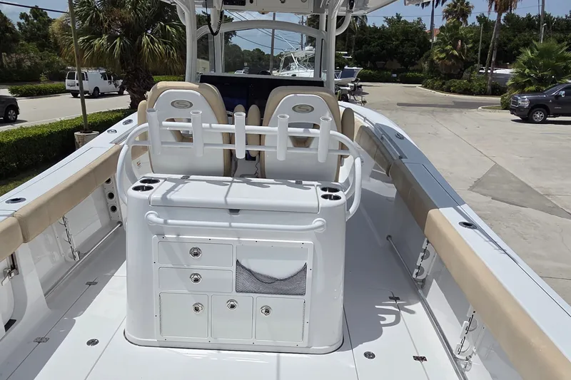 Slide: The Image of 2018 Sportsman Open 312 Center Console boat with seating and storage, parked outdoors. - 5