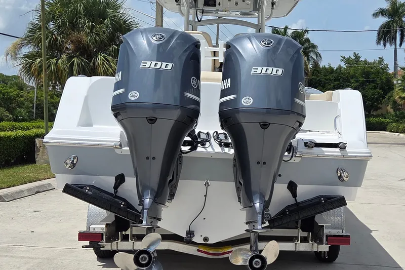 Slide: The Image of 2018 Sportsman Open 312 Center Console with twin Yamaha 300 engines, parked outdoors. - 4