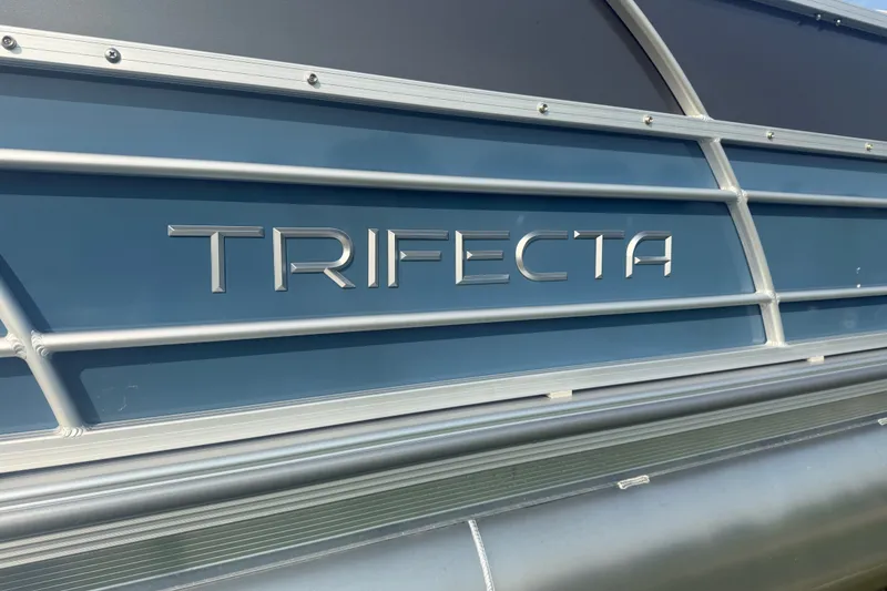 Slide: The Image of 2025 Trifecta 24 RF LE pontoon boat with sleek blue exterior and metallic branding. - 6