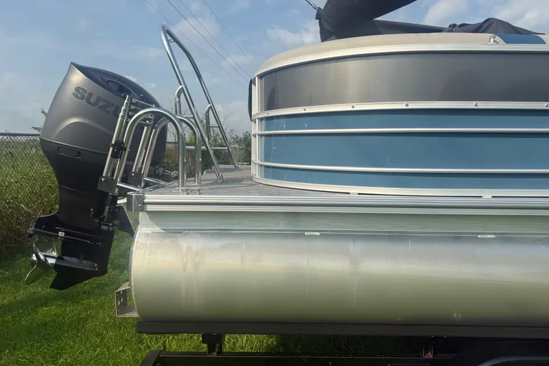 Slide: The Image of 2025 Trifecta 24 RF LE pontoon boat with Suzuki outboard motor, side view. - 4