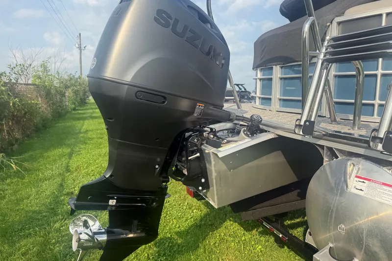 Slide: The Image of 2025 Trifecta 24 RF LE boat with Suzuki outboard motor on grassy area. - 5