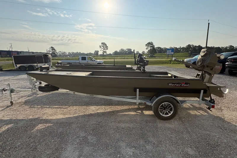 Slide: The Image of 2026 Gator Tail 1748 GATOR boat on trailer in sunny outdoor setting. - 2