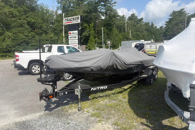 Slide: The Image of Covered 2015 Nitro Z-8 DC boat on trailer at dealership, surrounded by vehicles and trees. - 2