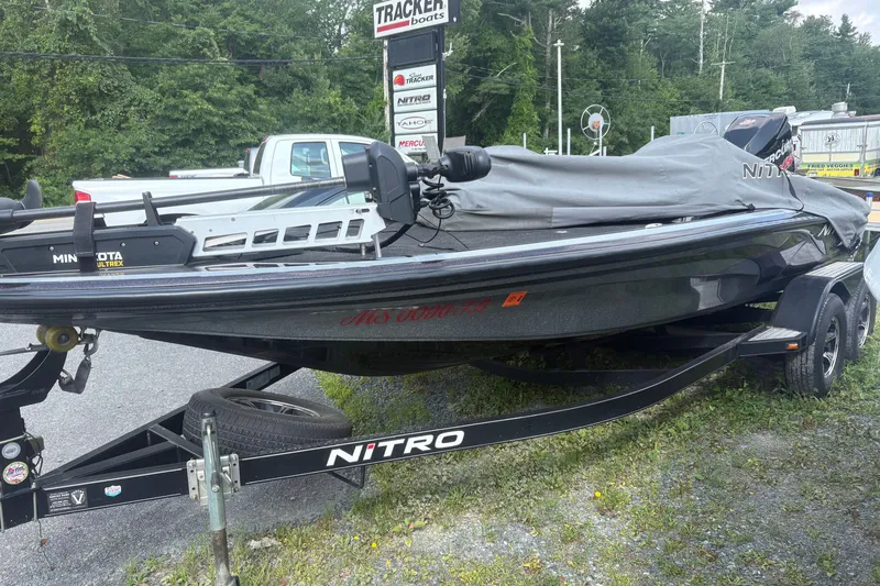Slide: The Image of 2015 Nitro Z-8 DC boat on trailer, covered, with Minn Kota Ultrex motor, parked outdoors. - 11