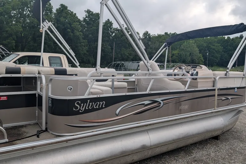 Slide: The Image of 2005 Sylvan 8520 Mirage Cruise RE pontoon boat with canopy, parked outdoors. - 2