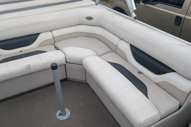 Slide: The Image of 2005 Sylvan 8520 Mirage Cruise RE boat interior with beige seating and carpeted floor. - 5