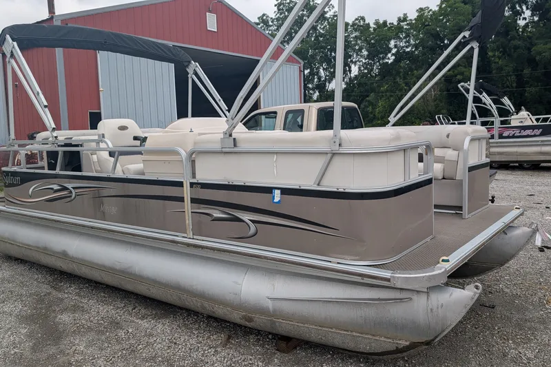 Slide: The Image of 2005 Sylvan 8520 Mirage Cruise RE pontoon boat parked near a red barn. - 1