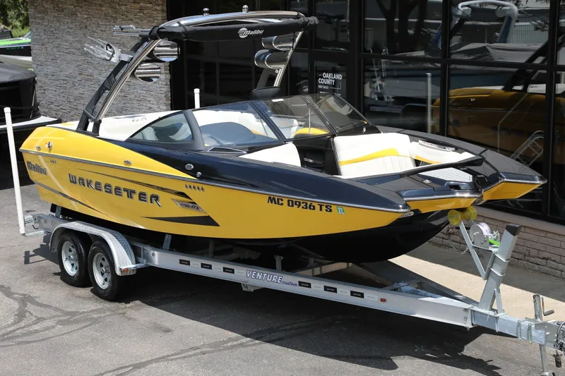 Slide: The Image of 2014 Malibu Wakesetter 22 MXZ boat on trailer, yellow and black design. - 2