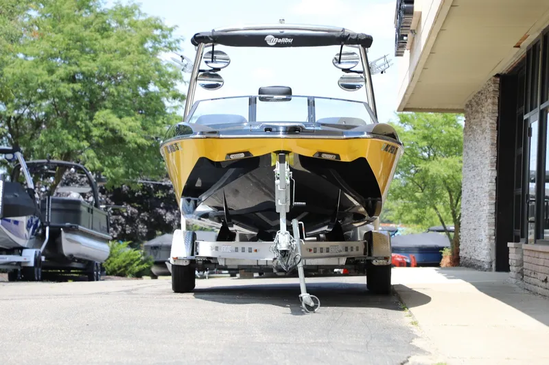 Slide: The Image of 2014 Malibu Wakesetter 22 MXZ boat on trailer, parked outdoors. - 3
