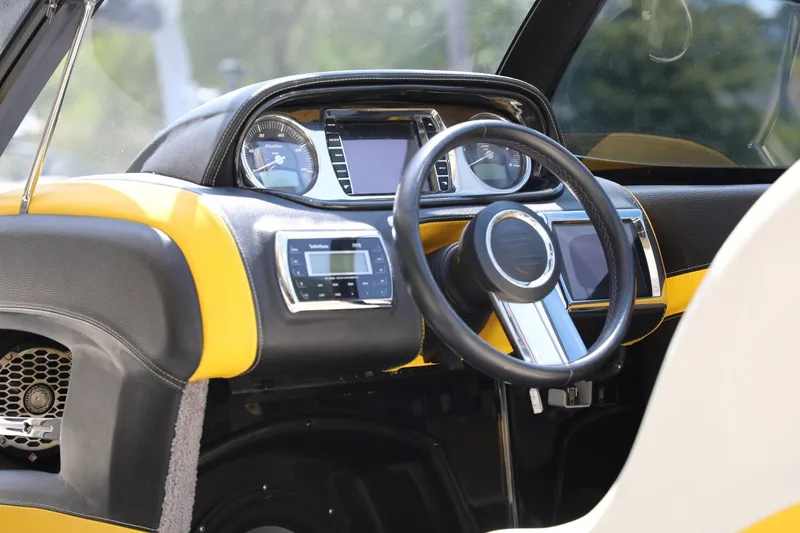Slide: The Image of Interior dashboard of a 2014 Malibu Wakesetter 22 MXZ boat, featuring modern controls and steering. - 4