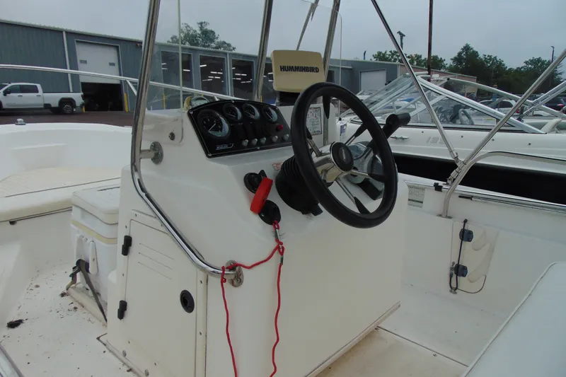 Slide: The Image of 2002 Boston Whaler 160 Dauntless boat cockpit with steering wheel and control panel. - 7