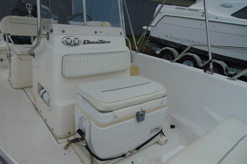 Slide: The Image of 2002 Boston Whaler 160 Dauntless interior with seating and storage features. - 12