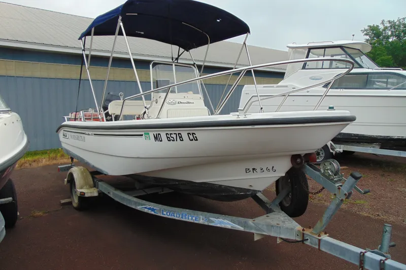 The Image of 2002 Boston Whaler 160 Dauntless boat on trailer with blue canopy. - 1