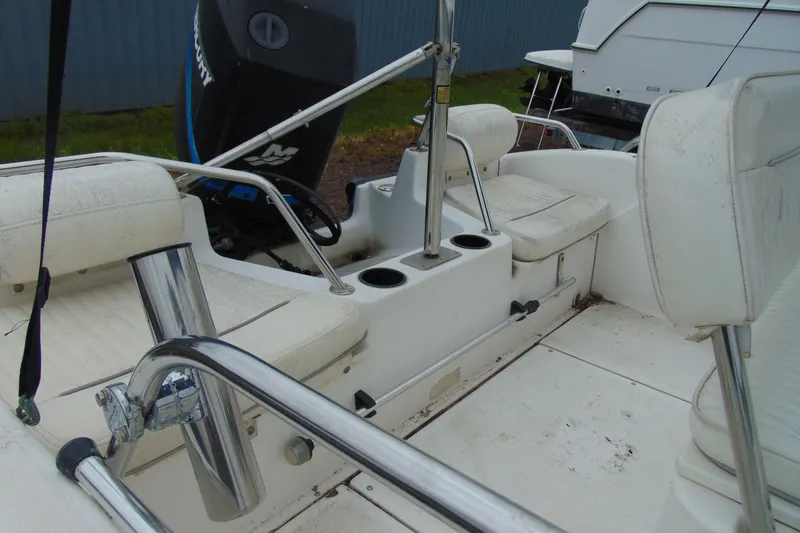 Slide: The Image of 2002 Boston Whaler 160 Dauntless boat interior with seating and motor, showcasing durability and design. - 13