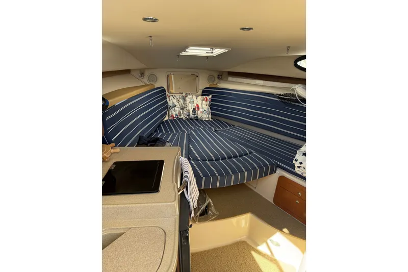 Slide: The Image of Interior of 2006 Wellcraft 290 Coastal boat with striped seating and compact kitchen area. - 11