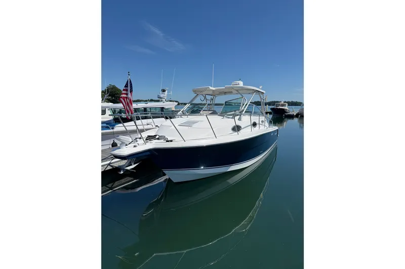 The Image of 2006 Wellcraft 290 Coastal boat docked in a marina under clear blue skies. - 1