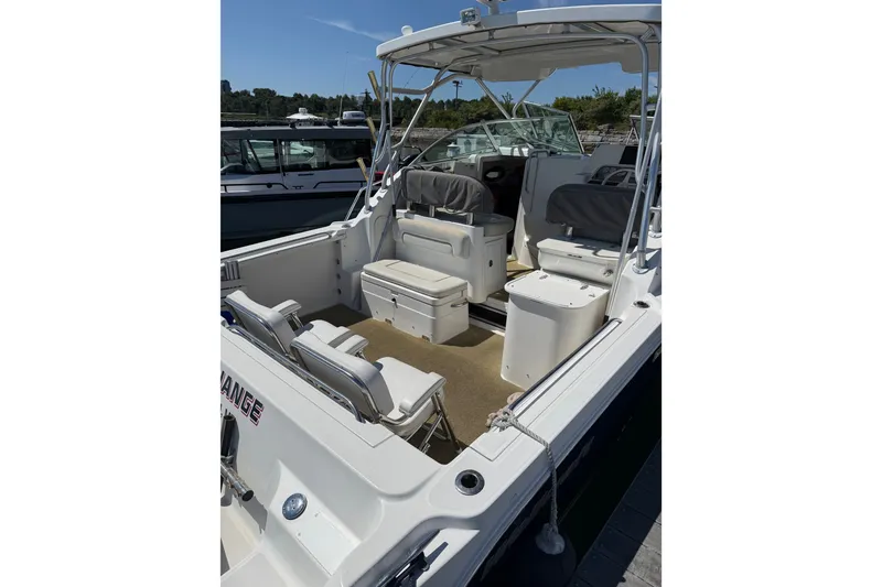 Slide: The Image of 2006 Wellcraft 290 Coastal boat interior with seating and helm, docked under clear skies. - 3