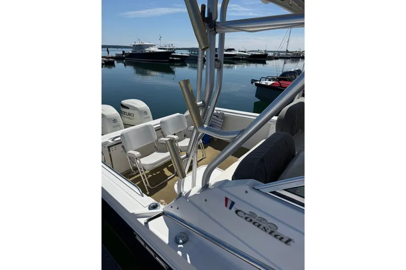 Slide: The Image of 2006 Wellcraft 290 Coastal boat docked, featuring seating and Suzuki engines. - 4