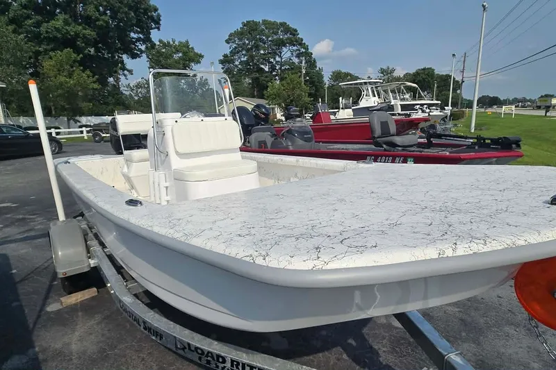 Slide: The Image of 2027 Coastal Skiff 171 boat on trailer, parked outdoors, sunny day. - 2