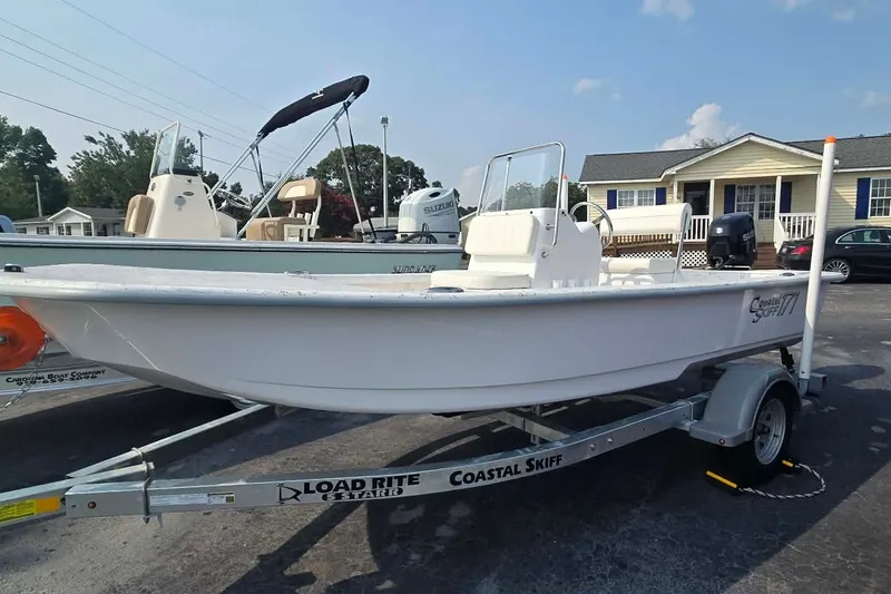The Image of 2027 Coastal Skiff 171 boat on Load Rite trailer, parked outdoors on a sunny day. - 0