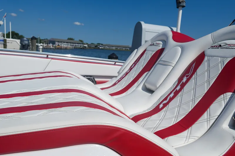 Slide: The Image of Luxurious MTI V42 boat seats with red and white design, docked by the water. - 9