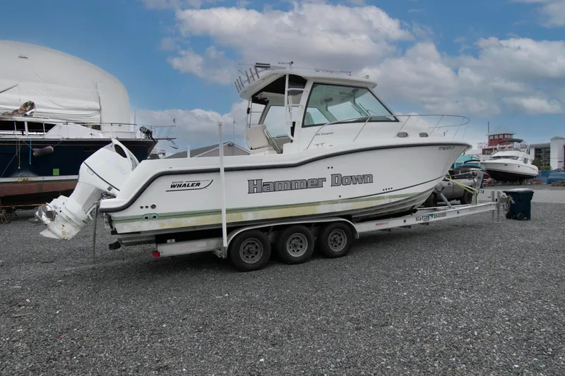 Slide: The Image of 2016 Boston Whaler 315 Conquest boat on trailer, labeled "Hammer Down," in a marina setting. - 3