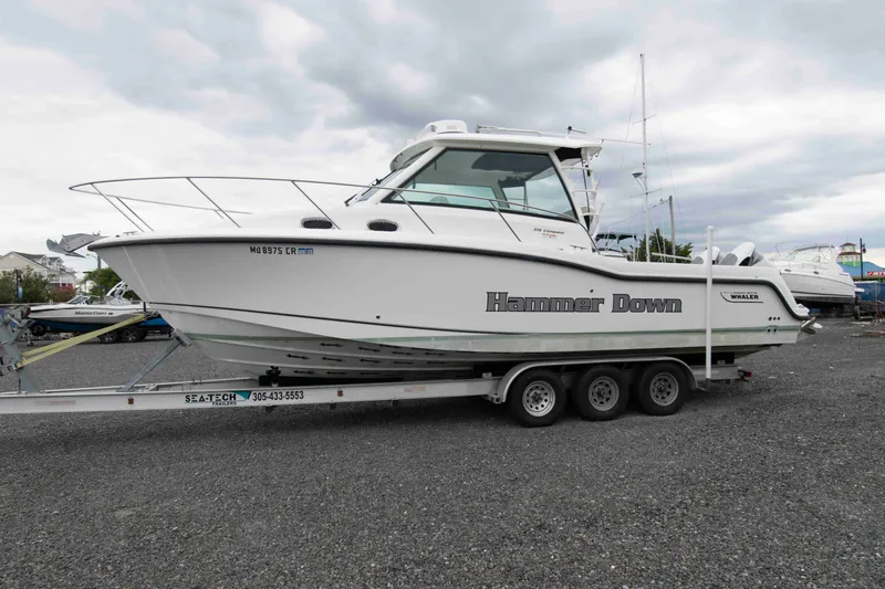 Slide: The Image of 2016 Boston Whaler 315 Conquest boat on trailer, labeled "Hammer Down," in outdoor setting. - 6