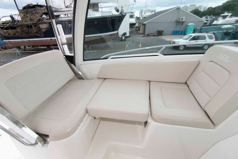 Slide: The Image of 2016 Boston Whaler 315 Conquest interior seating area with beige cushions. - 10