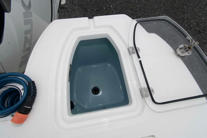 Slide: The Image of Livewell on 2016 Boston Whaler 315 Conquest boat, featuring a clear lid and hose. - 18