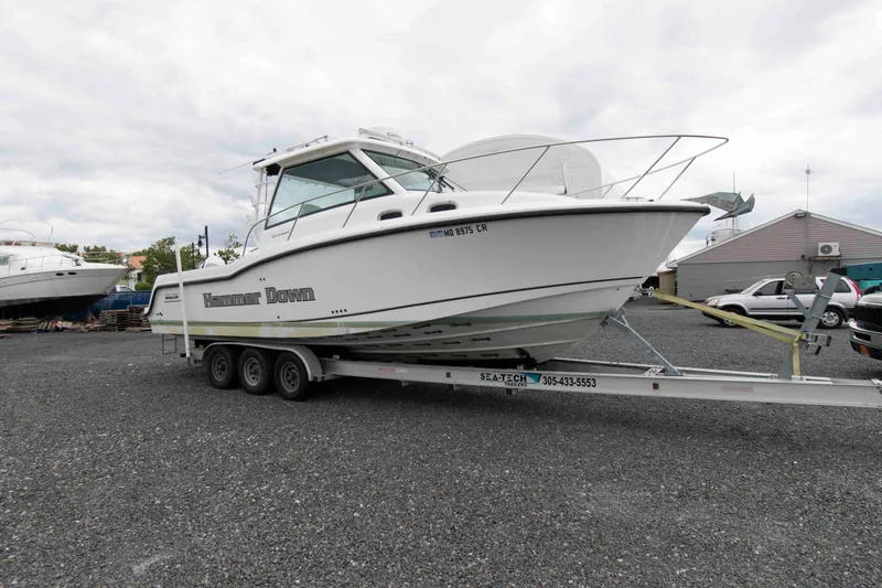 Slide: The Image of 2016 Boston Whaler 315 Conquest boat on trailer in a gravel lot. - 4