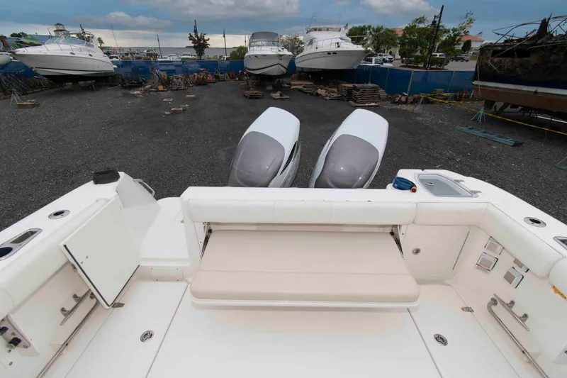 Slide: The Image of 2016 Boston Whaler 315 Conquest boat with dual engines in a marina setting. - 8