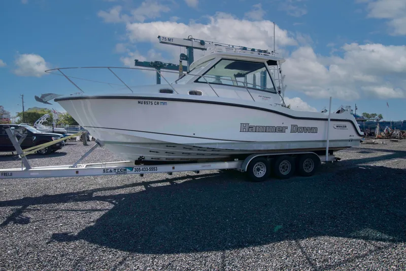 Slide: The Image of 2016 Boston Whaler 315 Conquest boat on trailer, labeled "Hammer Down," under a clear sky. - 5