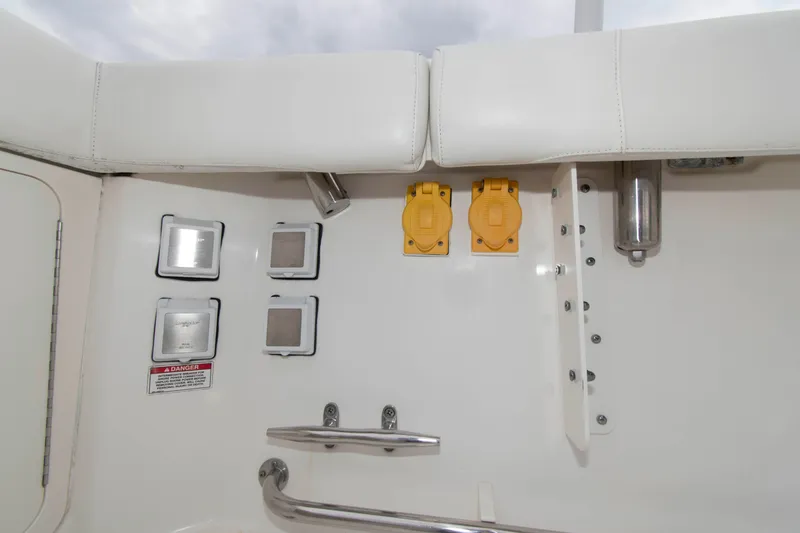 Slide: The Image of 2016 Boston Whaler 315 Conquest boat interior with electrical outlets and safety warning. - 19