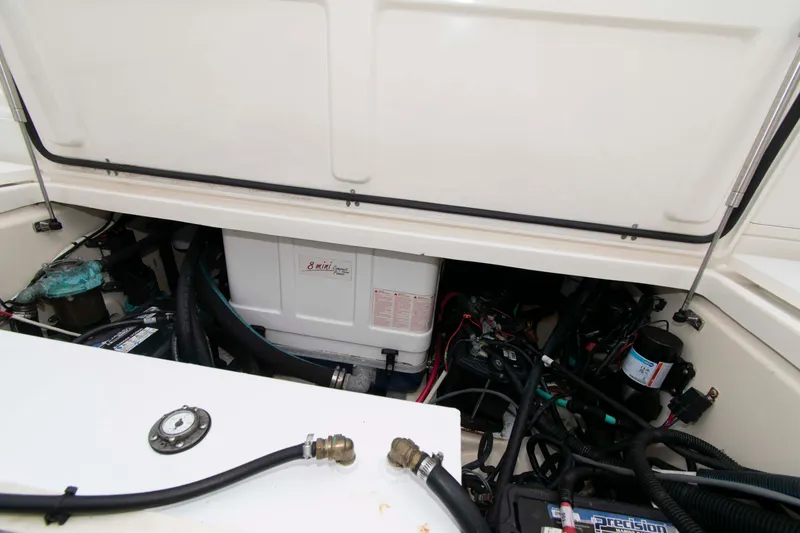 Slide: The Image of Engine compartment of a 2016 Boston Whaler 315 Conquest, showcasing mechanical components and wiring. - 31