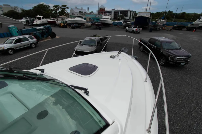 Slide: The Image of 2016 Boston Whaler 315 Conquest boat in a marina with parked vehicles. - 21