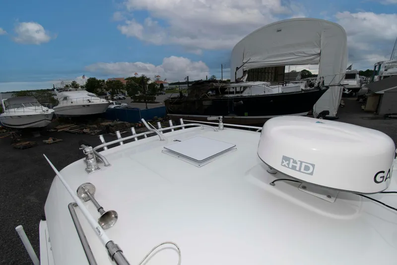Slide: The Image of 2016 Boston Whaler 315 Conquest boat docked, featuring radar and clear sky background. - 20