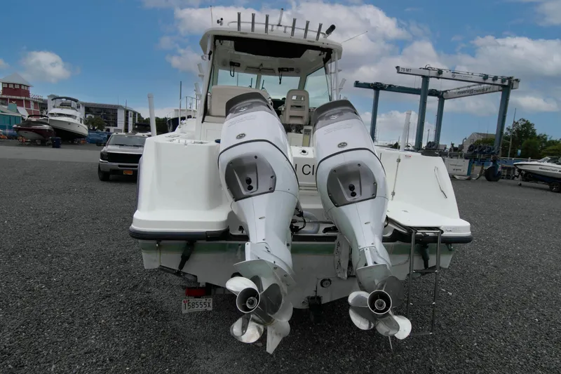Slide: The Image of 2016 Boston Whaler 315 Conquest with dual outboard engines in a marina setting. - 15