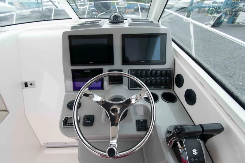 Slide: The Image of 2016 Boston Whaler 315 Conquest helm with modern navigation displays and controls. - 13